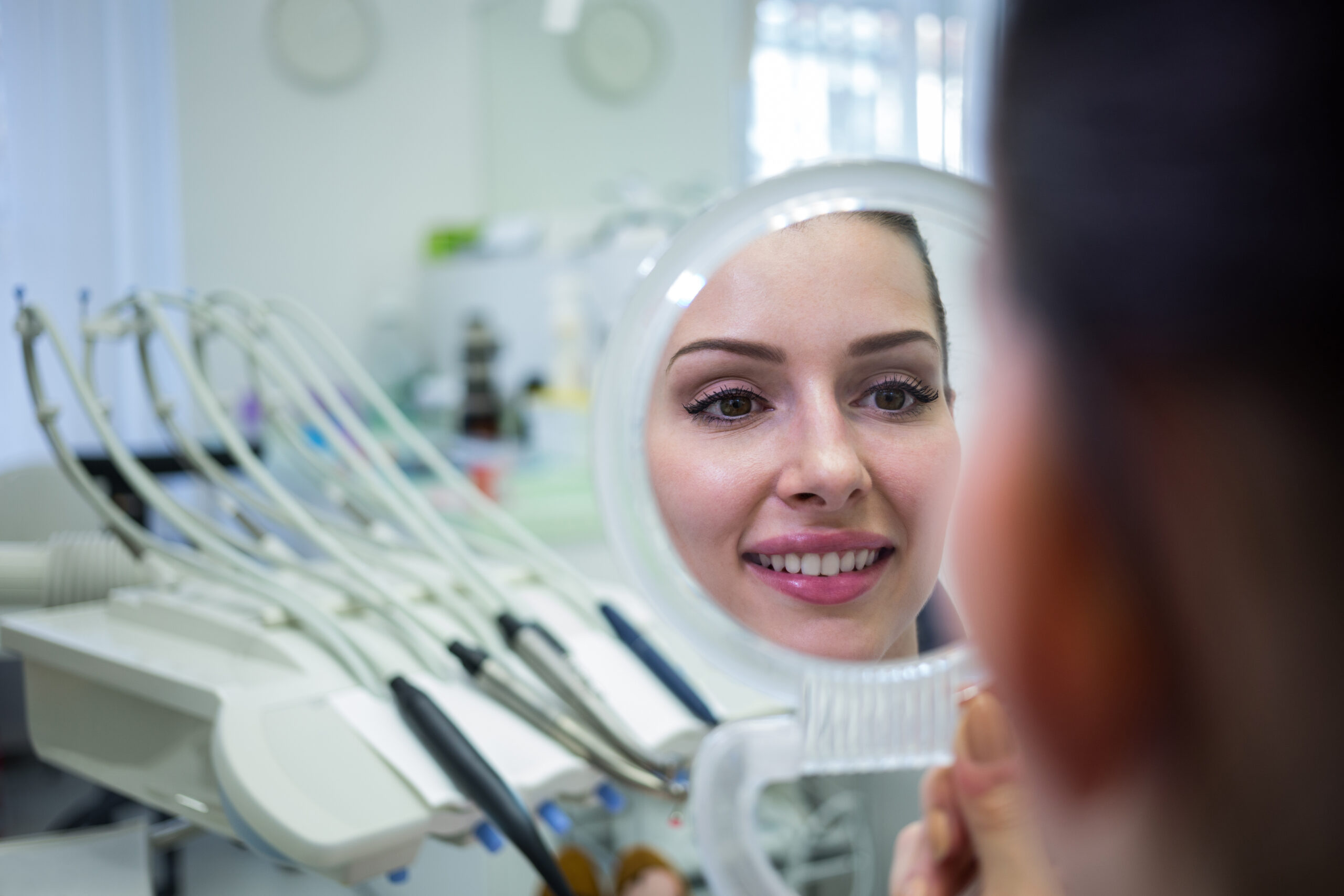 A woman looking at her smile in a mirror